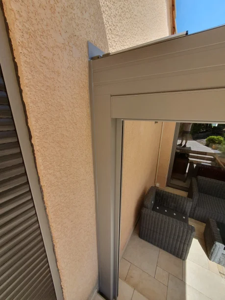 Pergola bioclimatique grise en aluminium Profils Systèmes à Teyran détail du poteau contre la facade