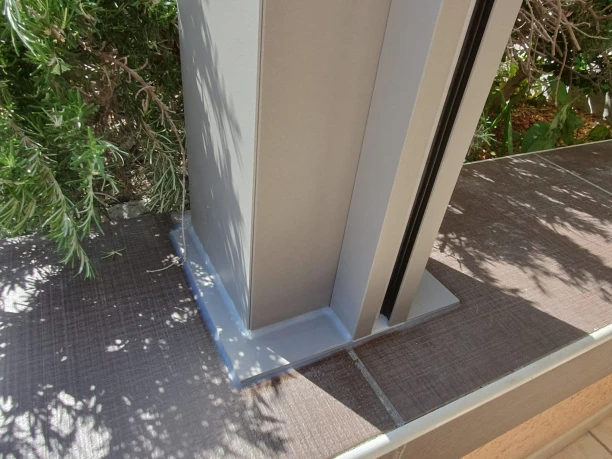 Pergola bioclimatique grise en aluminium Profils Systèmes à Teyran détail du poteau fixé au muret