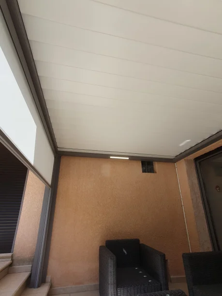 Pergola bioclimatique grise en aluminium Profils Systèmes à Teyran lames fermées et led allumé vue de l'intérieur