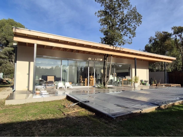 Baie vitrée coulissante 2 vantaux ouverture centrale et châssis fixe aluminium Profils Systèmes villa bois Montpellier vue extérieure