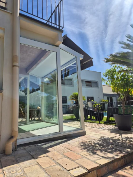 Véranda aluminium blanche Profils Systèmes sur mesure à Montpellier vue extérieure latérale gauche