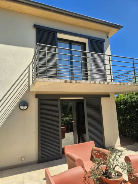 Volets coulissants lames fixes ajourées gris anthracite aluminium modèle Paris Ehret Bouzigues vue extérieure balcon ouvert