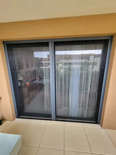 Moustiquaire plissée gris anthracite aluminium Cosywee Castries vue extérieure baie vitrée