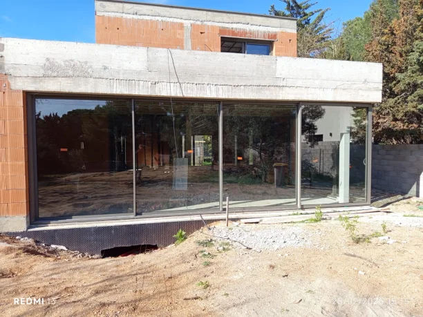 Baie vitrée coulissante d’angle en aluminium Profils Systèmes fabriquée par ALU TECH, vue extérieure