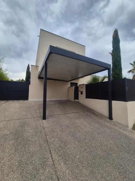 Carport gris anthracite aluminium adossé poteau déporté Hérault vue extérieure sous toiture