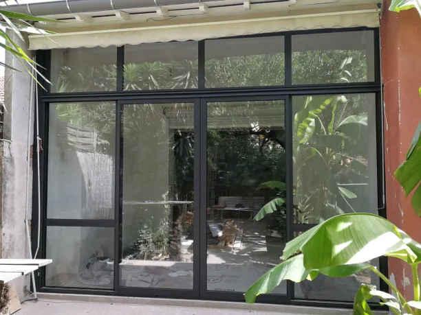 Baie vitrée coulissante aluminium Profils Systèmes fabrication ALU TECH jardin Jacou vue extérieure