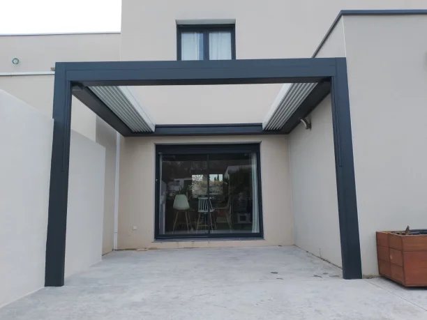 Pergola bioclimatique à toit rétractable grise aluminium Marquises et store projection Hérault vue extérieure face