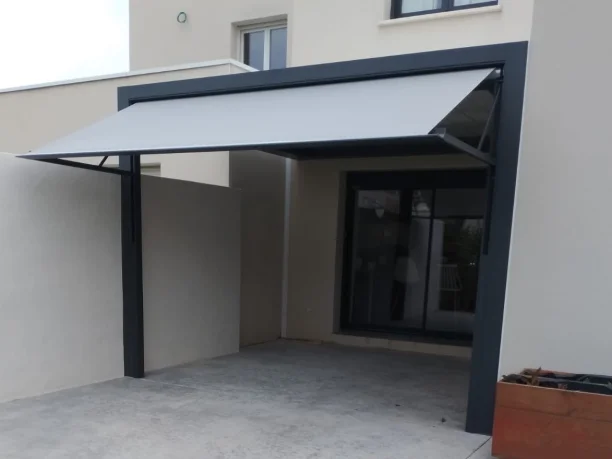 Pergola bioclimatique à toit rétractable grise aluminium Marquises et store projection Hérault vue extérieure store ouvert
